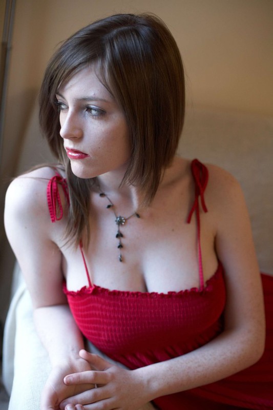 Серьезная дама оголила сиськи купаясь в свете окна 1 фотография