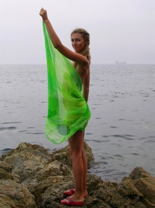 Голенькая бикса сидит на скале у моря 17 фотография